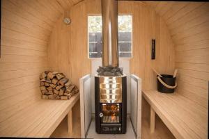 a small stove in a wooden room with logs at Gracieux Villa Lusso in Miyakojima