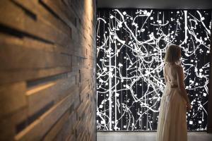 a woman in a wedding dress standing in front of a window at Gracieux Villa Lusso in Miyakojima