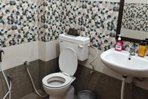 a bathroom with a toilet and a sink at Amantran Farm Retreat in Varanasi +16 photos