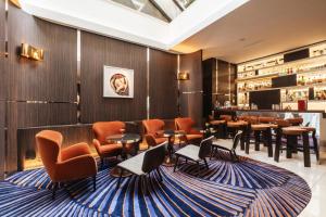 a restaurant with orange chairs and tables and a bar at Hôtel Bel Ami in Paris