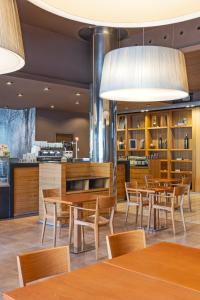 a dining room with wooden tables and chairs at Hotel SB Ciutat Tarragona in Tarragona