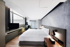 a bedroom with a large bed and a tv at CHECK inn Taipei Nanjing in Taipei