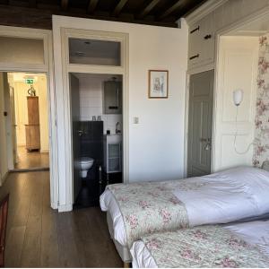 a bedroom with a bed and a kitchen at Inn de Vijf Sinnen in Geertruidenberg
