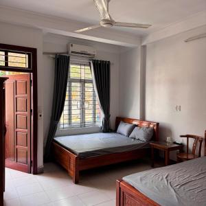 a bedroom with a bed and a window at Nhà Nghỉ Bình An in Kỳ Lừa