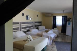 a group of four beds in a room at Ruacana Guest House in Ruacana