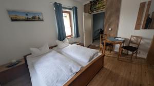 a bedroom with a large bed with white sheets at Dresdner Höhe in Dresden