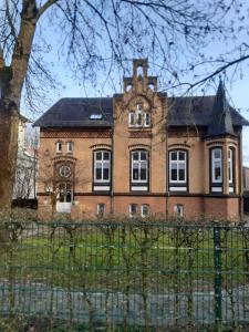 a large brick building with a clock on it at Meeresleuchten 1 in Emden