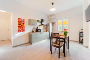 a kitchen with a table and a kitchen with a stove at 7th Floor - Donoratico in Cagliari