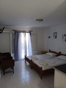 ein Schlafzimmer mit zwei Betten und einem Fenster in der Unterkunft Lissia Hotel in Skala Eresou
