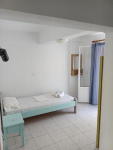 ein weißes Zimmer mit einem Bett und einem Spiegel in der Unterkunft Lissia Hotel in Skala Eresou