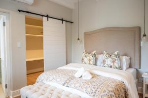 a bedroom with a large bed with a large headboard at Hoof House in Riebeek-Kasteel