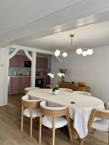 a dining room with a white table and chairs at Les Chantereines maison calme au cœur du vignoble champenois in Brugny-Vaudancourt