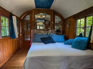 a bedroom with a large bed with blue pillows at L'Amandari - Provence holidays - Chambres d'hôtes avec jardin, piscine, jacuzzi, climatisation in Le Plan-de-la-Tour +59 photos