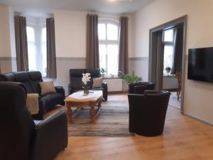 a living room with chairs and a table and a tv at Meeresleuchten 1 in Emden