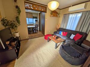 a living room with a couch and a table at 忍 Shinobi House in Yokohama