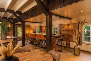a dining room with a bar and a brick wall at De Vuursteen | 10 - 40 pers. in Losser