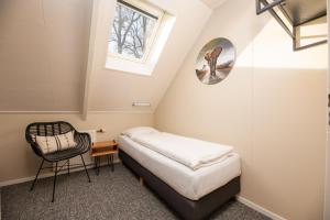 a small room with a bed and a window at De Vuursteen | 10 - 40 pers. in Losser
