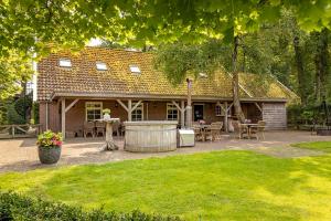 a house with a table and chairs in a yard at De Vuursteen | 10 - 40 pers. in Losser