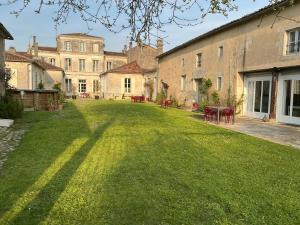 a large yard with chairs and a building at The Monet in Châteauneuf-sur-Charente