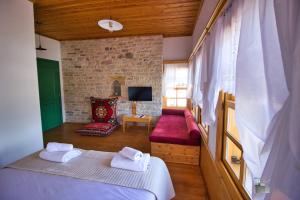a bedroom with two beds and a couch in a room at Argyropolis Boutique Hotel in Gjirokastër