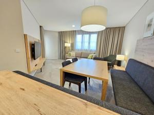 a living room with a table and a couch at Bergresort Gerlitzen in Treffen