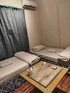 a room with two beds and a table with two cups at Colour Holidays in Cairo +48 photos