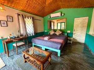 a bedroom with a bed and a table and a mirror at Samyama Retreat in Cola