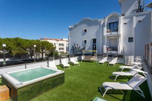 a patio with chairs and a hot tub on a building at Royal Boutique Hotel NUOVA GESTIONE in Riccione