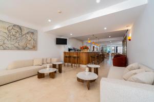 a living room with a couch and tables and a bar at Hotel Boutique Petit París in Port de Pollensa