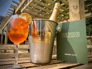 a glass of orange juice next to a bottle of champagne at Tyr Winch in Cardiff