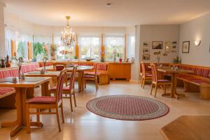 a restaurant with tables and chairs and a chandelier at Pension Herkules in Koserow