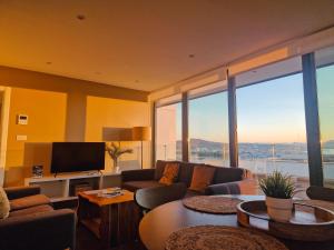 a living room with a couch and a flat screen tv at E1 Suites & Spa aparthotel style - Gym & Spa in Gibraltar