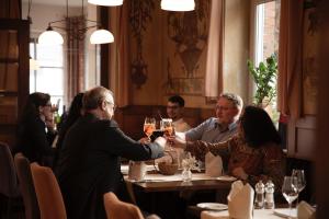 a group of people shaking hands at a table in a restaurant at Hotel Eisbach in Ransbach-Baumbach +19 photos