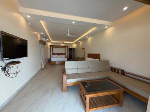a living room with a couch and a tv at Marron Sea View Resort in Patnem