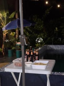 a table with bottles of beer and a plate of food at Private Villa in Masbate
