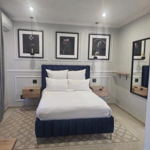 a bedroom with a blue and white bed and some pictures at Maison Akiba in Pretoria