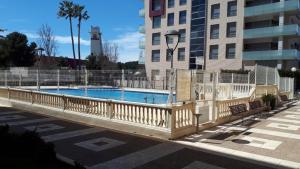 a large swimming pool with a fence around it at Apartment La Turquesa in La Pineda