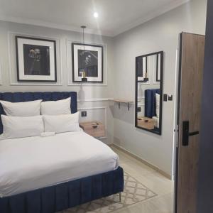 a bedroom with a blue and white bed and a mirror at Maison Akiba in Pretoria