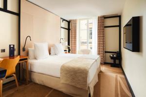 a hotel room with a bed and a television at Hôtel Bel Ami in Paris
