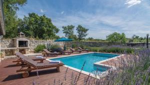 a swimming pool with chaise lounge chairs next to a patio at Villa Sabrane by Villas Guide in Bale