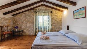 a bedroom with a large bed in a stone wall at Villa Sabrane by Villas Guide in Bale +5 photos