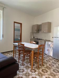 eine Küche mit Tisch, Stühlen und Kühlschrank in der Unterkunft Casa ALCA in Acquavella