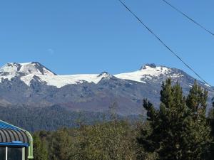 a snow covered mountain in the distance with a train at Cabaña Amancay Fuy in Puerto Fuy +6 photos