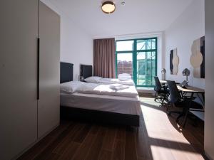 a bedroom with a bed and a desk and a window at Rezidence Třebíč in Třebíč