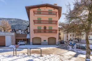 a apartment building with a balcony in the snow at Leonardo al Maso Fovo in Andalo