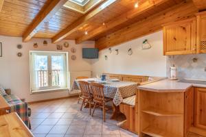 a kitchen and dining room with a table and chairs at Leonardo al Maso Fovo in Andalo +27 photos