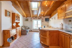 a large kitchen with wooden cabinets and a large island at Leonardo al Maso Fovo in Andalo