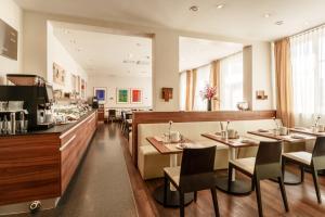 a restaurant with tables and chairs and a counter at Hotel Süd Graz in Graz