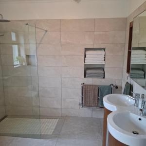 a bathroom with a glass shower and a sink at Cherrymount Cottage in Newcastle +30 photos
