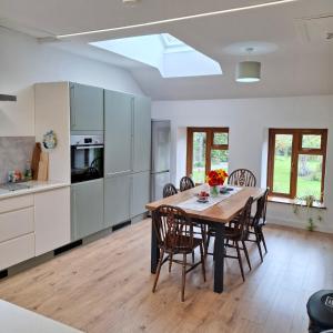 a kitchen and dining room with a table and chairs at Cherrymount Cottage in Newcastle
